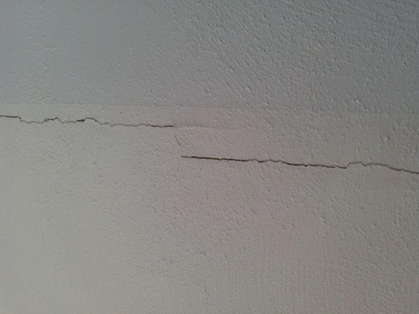 Горизонтальная трещина в стене. Усадочные трещины в штукатурном слое. Трещины на потолке. Трещины в перегородках. Мелкие трещины на стене.